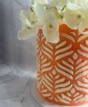 Close-up of peach buttercream wedding cake with piped leaf pattern and white hydrangea flowers in Orlando.