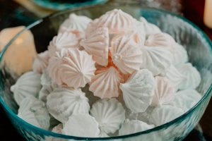 Delicate pink and white French meringue cookies in a glass bowl, perfect for baby showers in Central Florida, including Orlando, Daytona, and St. Augustine.