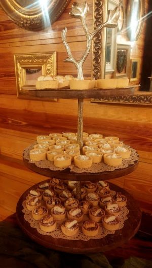 A rustic three-tiered stand featuring banana cream tartlets on top, coconut cream in the middle, and tiramisu tartlets on the bottom. Displayed at a Club Lake wedding dessert table with warm wood tones and gold accents, ideal for Orlando and Central Florida weddings.
