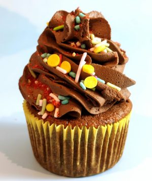 Rich chocolate cupcake topped with swirls of chocolate buttercream and colorful sprinkles, ideal for birthdays, kids’ parties, and festive celebrations.