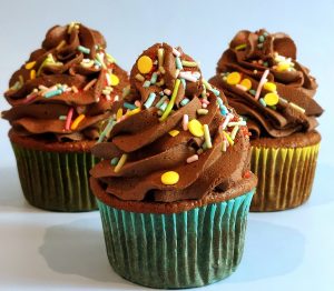 Three chocolate cupcakes topped with rich chocolate buttercream and colorful sprinkles, perfect for birthdays, classroom parties, and fun family celebrations.