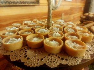 Bite-sized coconut cream tartlets topped with shredded coconut, displayed on a rustic wooden stand at Club Lake wedding venue. A tropical-inspired addition to Central Florida wedding dessert tables, perfect for Orlando, Sanford, and Apopka events.