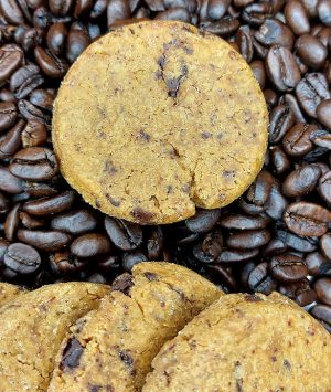 Close-up of dark chocolate espresso French sablé cookies displayed on a bed of roasted coffee beans—ideal for upscale dessert tables at weddings, corporate events, and evening parties in St. Augustine, Florida.