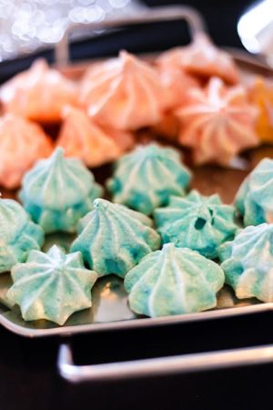 Elegant blue and blush French meringue cookies on a silver tray, styled for a modern wedding dessert table at New York Beer Project Orlando.