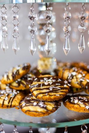 Chocolate drizzled French vanilla cookies with star sprinkles on a crystal chandelier dessert stand for weddings, corporate events, and parties in Central Florida.