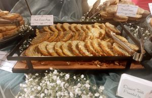 Glazed lemon poppy cookies served on wood tray at Tavares Pavilion wedding dessert table.