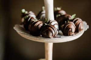 Elegant chocolate covered strawberries with a dark chocolate drizzle, displayed on a rustic event stand. Perfect for weddings, upscale parties, baby showers, and corporate events in Central Florida, including Orlando, St. Augustine, and Daytona.