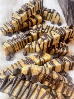 A stack of hand-crafted Italian biscotti cookies with chocolate drizzle and chips, perfect for wedding dessert tables, party favors, or corporate catering in Central Florida. Baked by The Cookie Jar Orlando for upscale events.