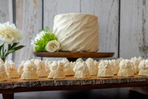 Ivory sweetheart cake with mini bundt cakes on rustic wood slab for weddings in Orlando, Daytona, and St. Augustine.