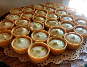 Mini key lime tartlets with a smooth citrus filling and graham-style crust, displayed on a lace doily at a Sterling Event Center wedding dessert table in Central Florida.