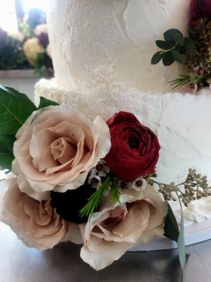 Buttercream wedding cake with lace fondant and fresh florals, perfect for elegant weddings at The Howey Mansion.