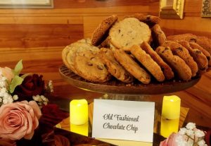 Platter of red velvet white chocolate chip cookies on display at rustic Orlando wedding dessert table with warm lighting.