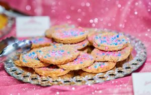 Pink and blue sprinkle sugar cookies on a crystal platter at an Orlando quinceañera dessert table.