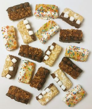 Assorted Rice Krispy treats dipped in chocolate and white chocolate, topped with rainbow sprinkles, mini marshmallows, and chocolate chips—perfect for birthdays, kids' parties, graduations, sweet sixteens, and quinceañeras.
