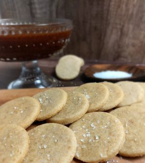 Delicate French sablé cookies topped with sea salt, arranged beside a bowl of rich caramel sauce – perfect for wedding dessert tables and upscale events in Orlando.