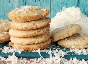 Stack of piña colada cookies topped with shredded coconut, ideal for tropical-themed weddings, showers, or summer events.