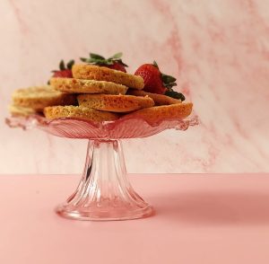 Strawberry shortcake cookies on a glass stand, ideal for weddings, baby showers, bridal showers, and summer celebrations.