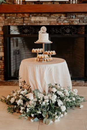 Small wedding cake with bundtlets on a tiered stand, surrounded by florals at Casani Estates near Orlando.