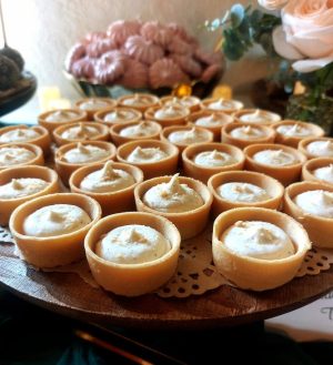 Mini vanilla cheesecake tartlets with graham crumb topping, served on a wedding dessert table in Orlando.