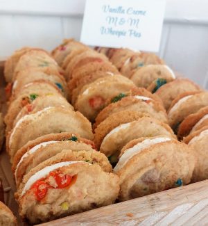Vanilla cream M&M whoopie pies displayed on a wedding dessert table at Historic Venue 1902 near Orlando.